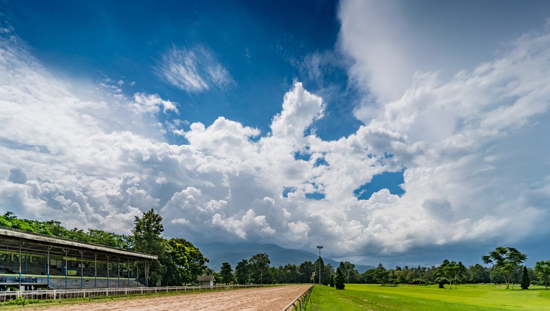 A racecourse set against a cloudy sky.