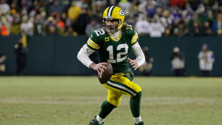 Green Bay Packers' Aaron Rodgers runs for a first down during the second half of an NFL football game against the Minnesota Vikings Sunday, Jan. 2, 2022, in Green Bay, Wis. (AP Photo/Matt Ludtke)