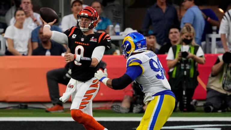 Cincinnati Bengals quarterback Joe Burrow (9) throws under pressure from Los Angeles Rams defensive end Aaron Donald (99) during the first half of the NFL Super Bowl 56 football game Sunday, Feb. 13, 2022, in Inglewood, Calif. (AP Photo/Tony Gutierrez)