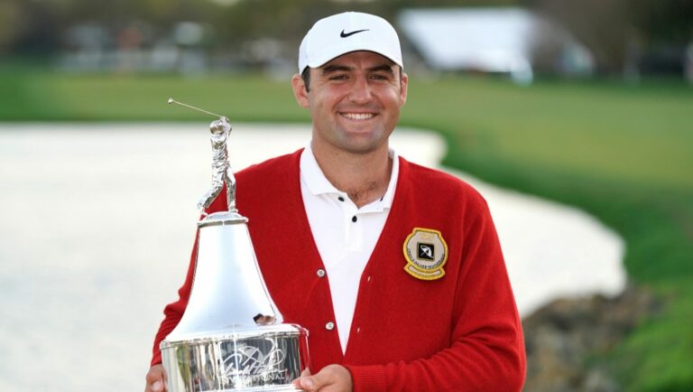 Scottie Scheffler holds the championship trophy after winning the Arnold Palmer Invitational golf tournament Sunday, March 6, 2022, in Orlando, Fla.