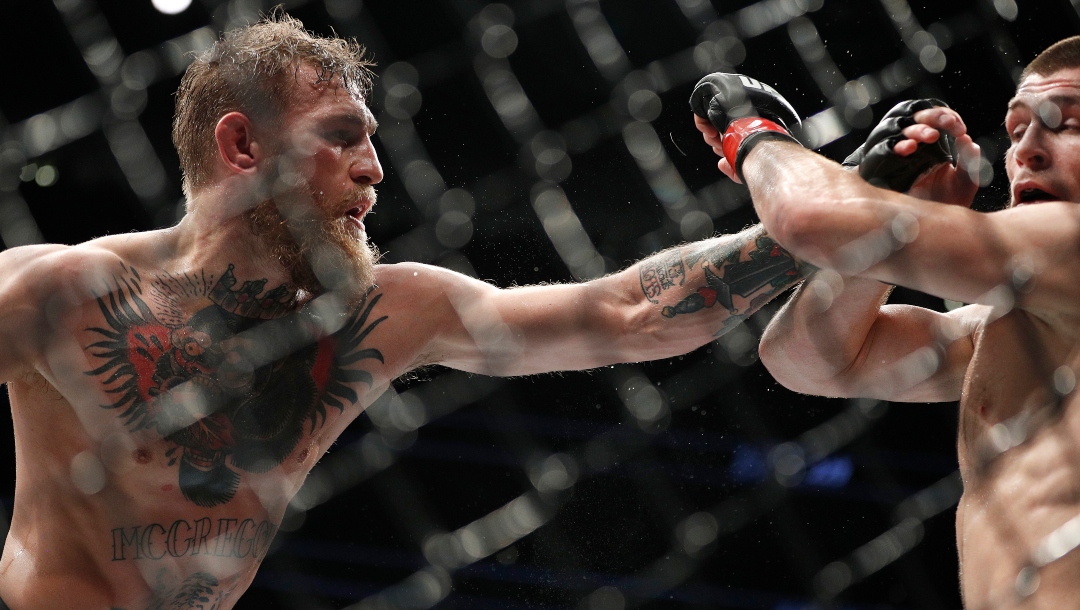 Conor McGregor, left, punches Khabib Nurmagomedov