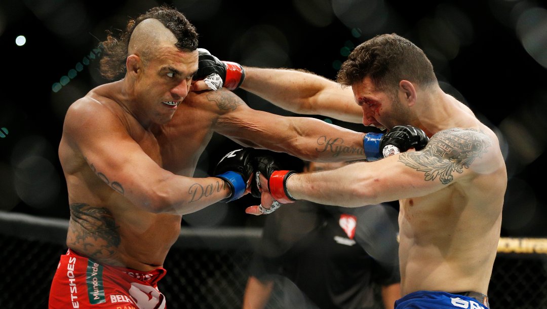 Chris Weidman, right, and Vitor Belfort trade blows during their middleweight mixed martial arts bout at UFC 187 on Saturday, May 23, 2015, in Las Vegas.