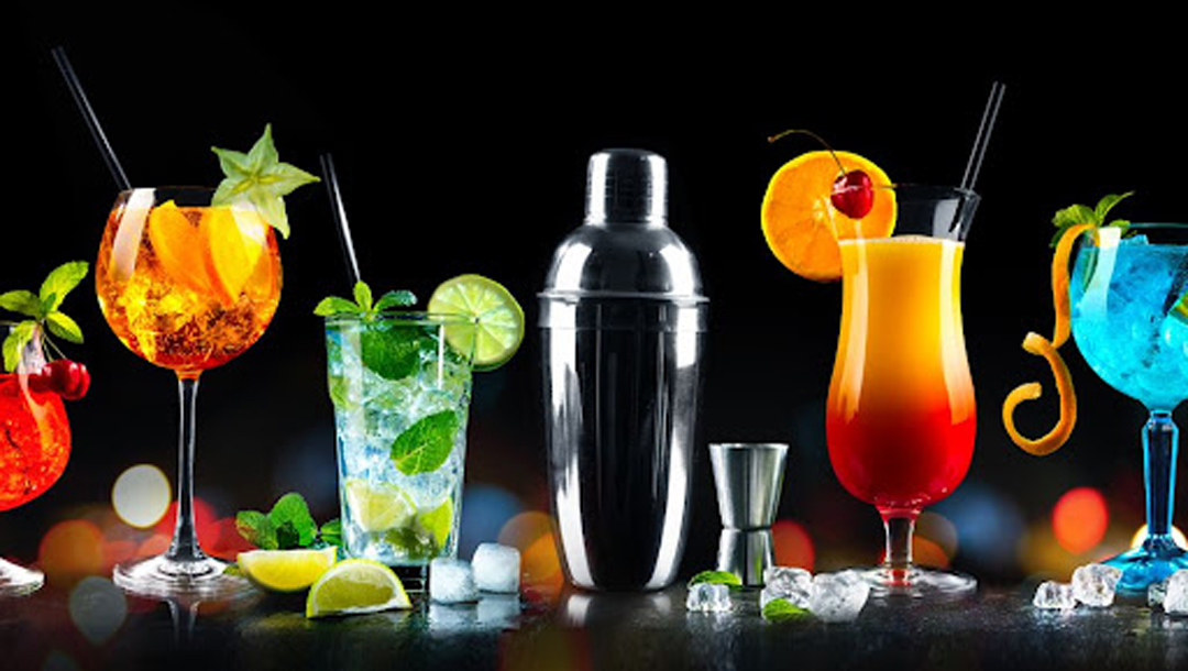 A variety of cocktails and a cocktail mixer.