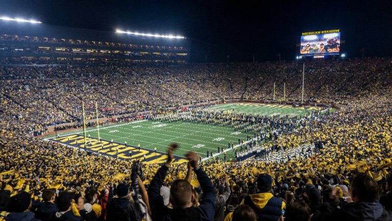 FILE - Fans cheer as the Michigan team takes the field at Michigan Stadium for an NCAA college football game against Wisconsin in Ann Arbor, Mich., Oct. 13, 2018. Michigan's Big House will be sitting empty when the leaves start to change this fall. From Ann Arbor to Los Angeles to Oxford, that most American of pursuits, college football, has either given up hope of getting in a traditional season or is flinging what amounts to a Hail Mary pass in a desperate attempt to hang on in the age of COVID-19. (AP Photo/Tony Ding, File)