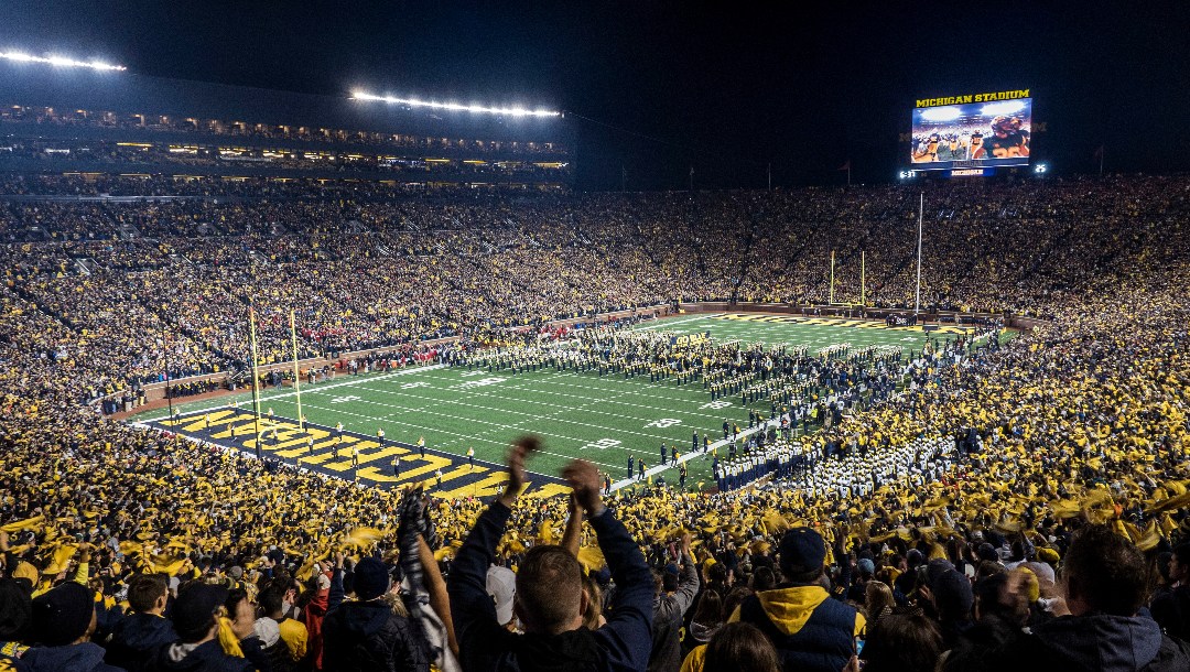 FILE - Fans cheer as the Michigan team takes the field at Michigan Stadium for an NCAA college football game against Wisconsin in Ann Arbor, Mich., Oct. 13, 2018. Michigan's Big House will be sitting empty when the leaves start to change this fall. From Ann Arbor to Los Angeles to Oxford, that most American of pursuits, college football, has either given up hope of getting in a traditional season or is flinging what amounts to a Hail Mary pass in a desperate attempt to hang on in the age of COVID-19. (AP Photo/Tony Ding, File)