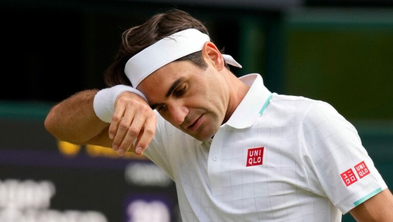 Switzerland's Roger Federer wipes his brow during the men's singles quarterfinals match against Poland's Hubert Hurkacz on day nine of the Wimbledon Tennis Championships in London.