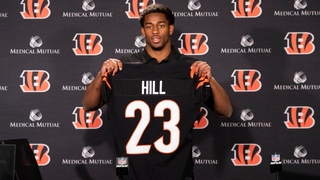 Cincinnati Bengals safety Daxton Hill holds up a team jersey