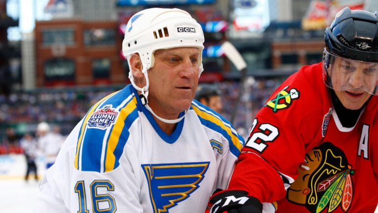 Former St. Louis Blues' Brett Hull, left, battles along the board with former Chicago Blackhawks' Grant Mulvey during the winter classic alumni outdoor hockey game at Busch Stadium, Saturday, Dec. 31, 2016, in St. Louis.