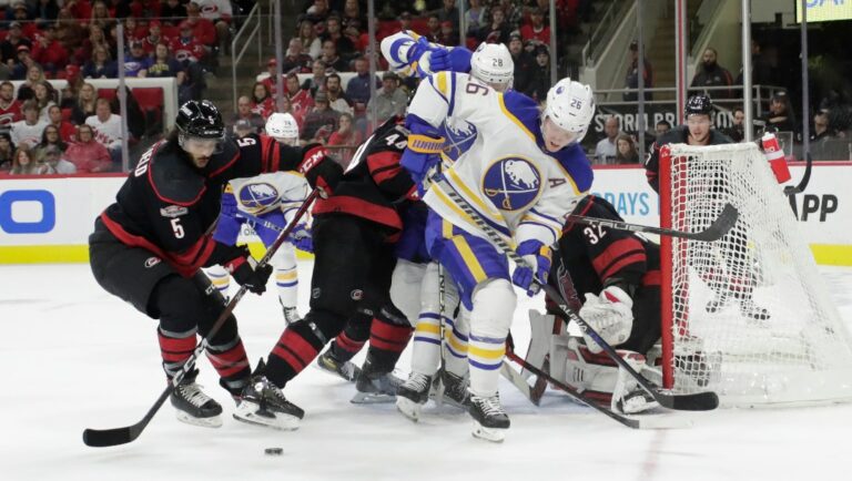 Carolina Hurricanes defenseman Jalen Chatfield (5), defenseman Calvin de Haan (44) and goaltender Antti Raanta (32) battle Buffalo Sabres defenseman Rasmus Dahlin (26) and left wing Zemgus Girgensons (28) during the first period of an NHL hockey game the Friday, Nov. 4, 2022, in Raleigh, N.C. (AP Photo/Chris Seward)
