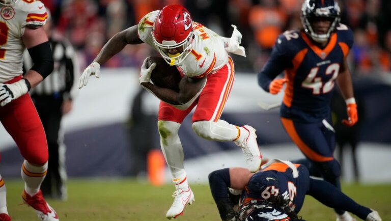 Kansas City Chiefs running back Jerick McKinnon (1) eludes a tackle by Denver Broncos linebacker Alex Singleton (49) in the second half of an NFL football game Sunday, Dec. 11, 2022, in Denver. (AP Photo/David Zalubowski)
