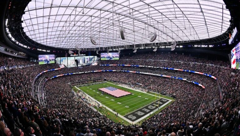 An American is unfurled during the national anthem in Allegiant Stadium before an NFL football game between the New England Patriots and Las Vegas Raiders, Sunday, Dec. 18, 2022, in Las Vegas.