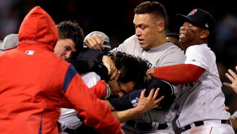 New York Yankees right fielder Aaron Judge puts Boston Red Sox relief pitcher Joe Kelly in a headlock as they fight during the seventh inning of a baseball game at Fenway Park in Boston, Wednesday, April 11, 2018. At right is Boston Red Sox third baseman Rafael Devers.