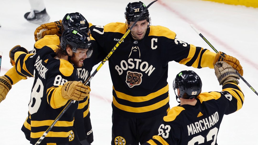 Boston Bruins' Patrice Bergeron (37) celebrates his goal against the Toronto Maple Leafs with Brad Marchand (63), David Pastrnak (88) and Matt Grzelcyk (48) during the first period of an NHL hockey game Saturday, Jan. 14 2023, in Boston.