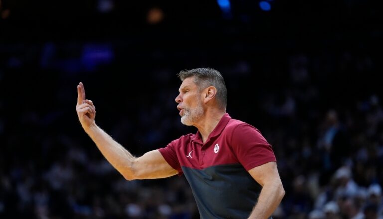 A coach signalling to players holding two fingers up in the air.