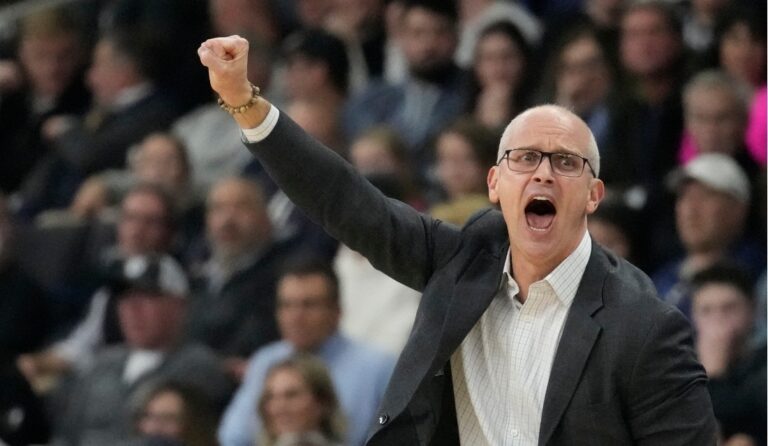 Man in a suit shouting with his fist in the air.
