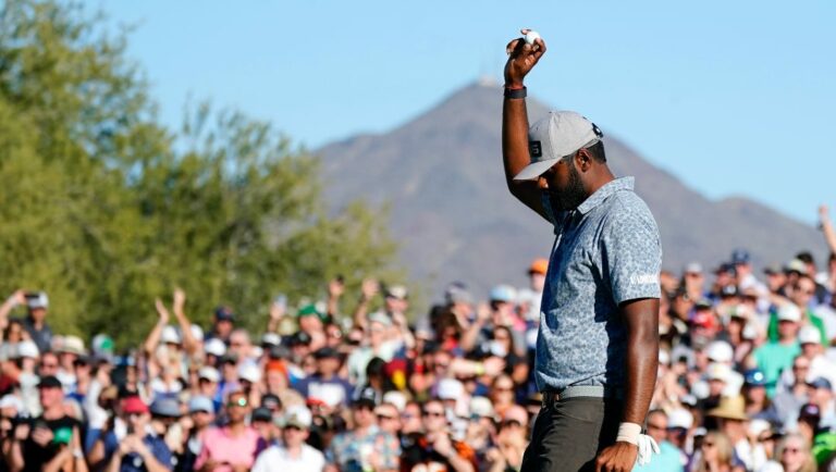 Sahith Theegala acknowledges the cheering crowd after putting out on the 18th green during the final round of the Phoenix Open golf tournament Sunday, Feb. 13, 2022, in Scottsdale, Ariz.