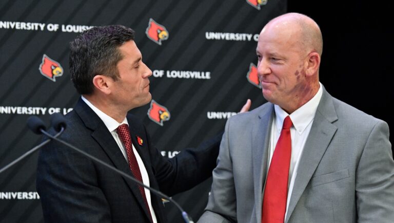 Louisville athletic director Josh Heird, left, shakes hands with newly named football coach Jeff Brohm in Louisville, Ky., Thursday, Dec. 8, 2022. (AP Photo/Timothy D. Easley)