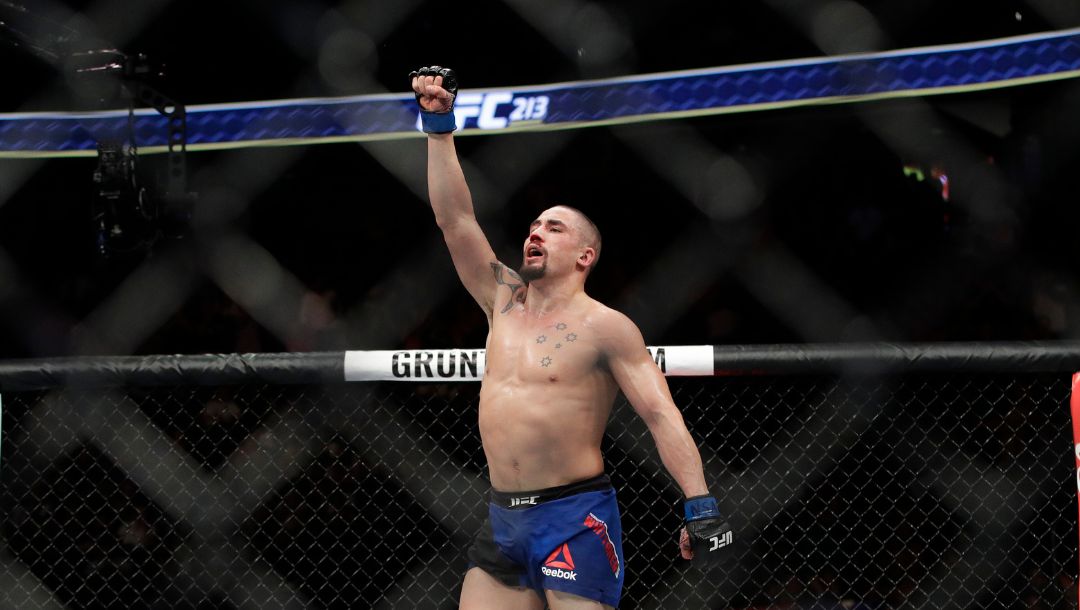 Robert Whittaker celebrates after defeating Yoel Romero in a middleweight championship mixed martial arts bout at UFC 213.