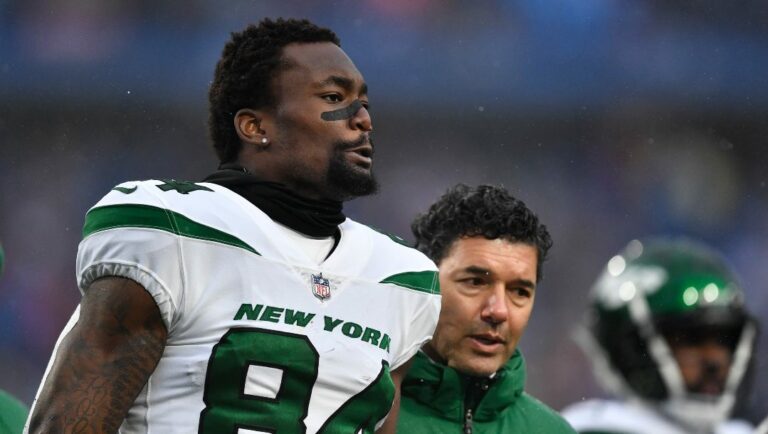 New York Jets wide receiver Corey Davis (84) walks off the field with trainers during the first half of an NFL football game against the Buffalo Bills in Orchard Park, N.Y., Sunday, Dec. 11, 2022.
