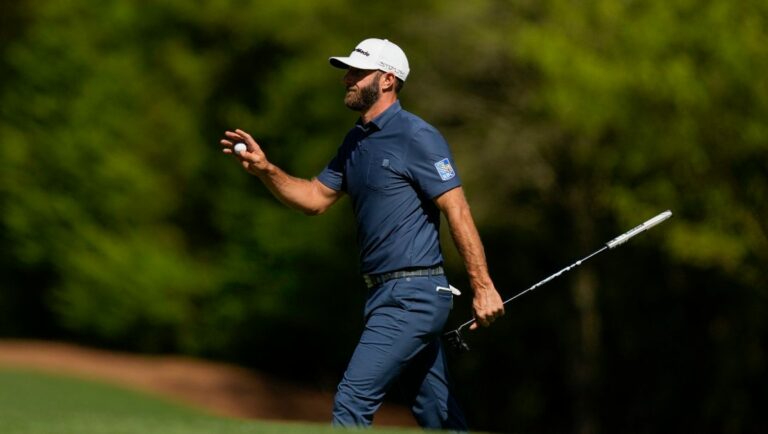 Dustin Johnson holds up his ball after putting on the 11th hole during the final round at the Masters golf tournament on Sunday, April 10, 2022, in Augusta, Ga.
