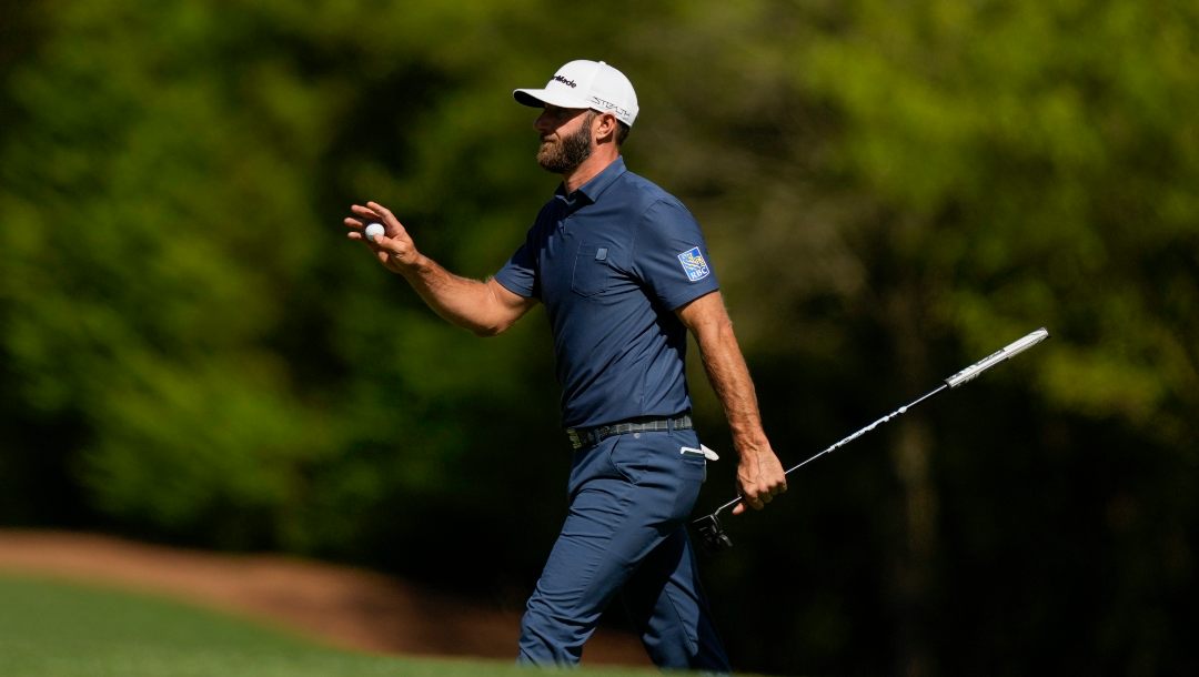 Dustin Johnson holds up his ball after putting on the 11th hole during the final round at the Masters golf tournament on Sunday, April 10, 2022, in Augusta, Ga.