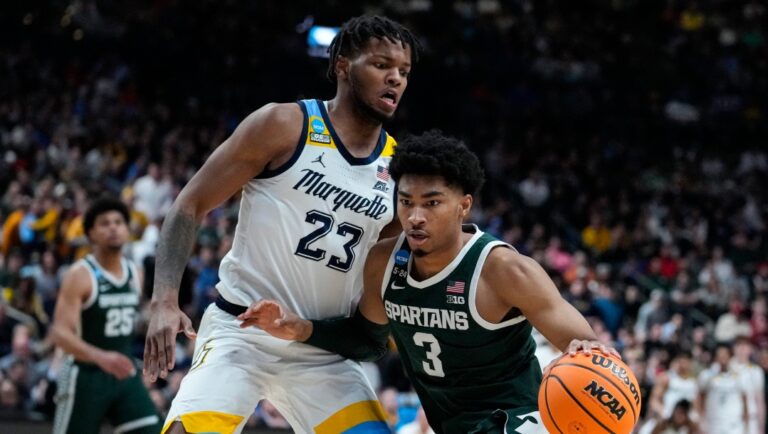Michigan State guard Jaden Akins (3) drives on Marquette forward David Joplin (23) in the second half of a second-round college basketball game in the men's NCAA Tournament in Columbus, Ohio, Sunday, March 19, 2023. (AP Photo/Michael Conroy)