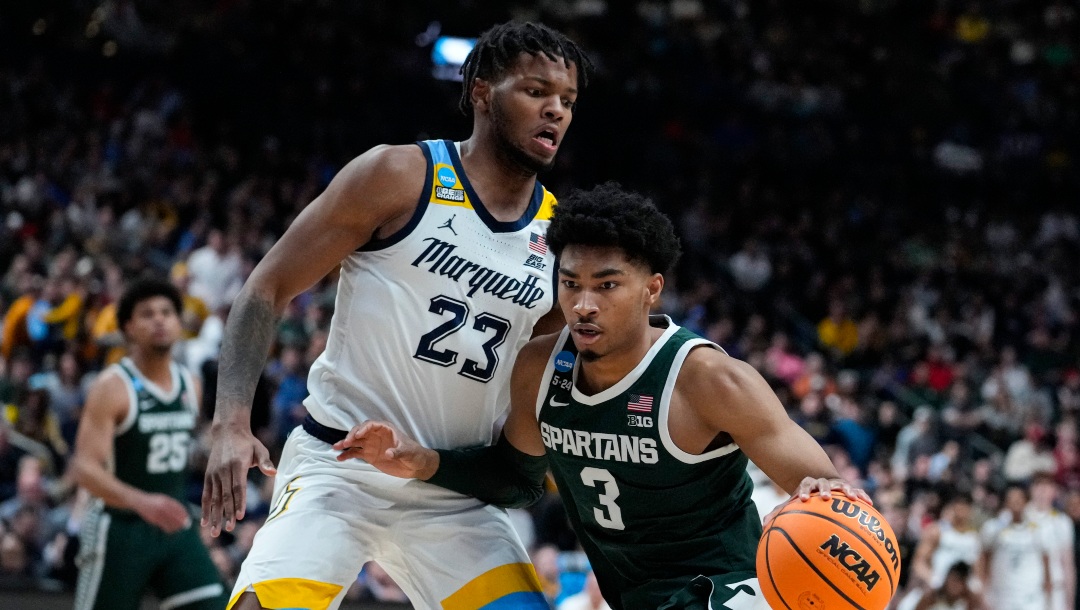 Michigan State guard Jaden Akins (3) drives on Marquette forward David Joplin (23) in the second half of a second-round college basketball game in the men's NCAA Tournament in Columbus, Ohio, Sunday, March 19, 2023. (AP Photo/Michael Conroy)