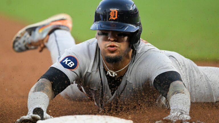Detroit Tigers' Javier Baez dives safely to third from second on a sacrifice fly by teammate Robbie Grossman during the fifth inning of a baseball game against the Kansas City Royals, Tuesday, July 12, 2022, in Kansas City, Mo.