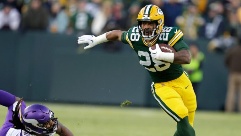 Green Bay Packers running back AJ Dillon (28) runs from Minnesota Vikings linebacker Za'Darius Smith (55) during the first half of an NFL football game, Sunday, Jan. 1, 2023, in Green Bay, Wis. (AP Photo/Matt Ludtke)