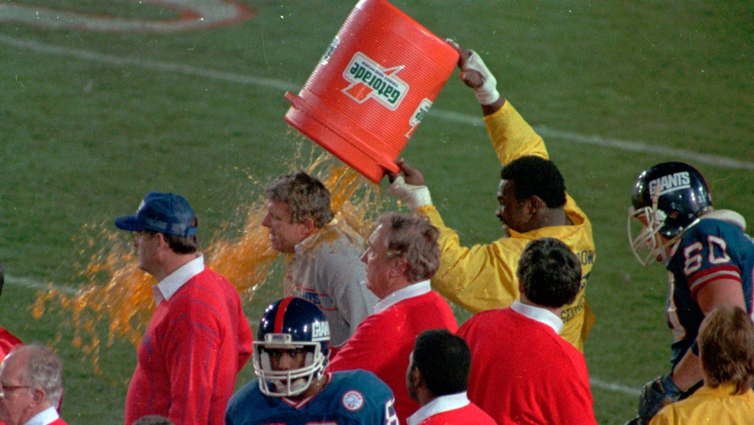 Wearing a Rose Bowl security jacket, New York Giants Harry Carson dumps a bucket of Gatorade on coach Bill Parcells toward the end of Super Bowl XXI against the Denver Broncos, Jan.25, 1987. Giants won, 39-20. (AP Photo/Douglas C. Pizac)