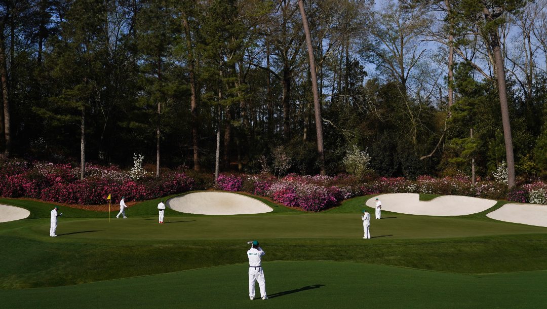 Masters' caddies examine the green on the 13th hole during a practice round for the Masters golf tournament on Monday, April 4, 2022, in Augusta, Ga. The Masters has no shortage of storylines at Augusta National. Tiger Woods returns after nearly two months. This will be only his third appearance against elite competition since last year's Masters. Rory McIlroy is in good form as he goes for the final leg of the career Grand Slam. And they share the stage with 18 players who most fans haven't see in more than nine months.