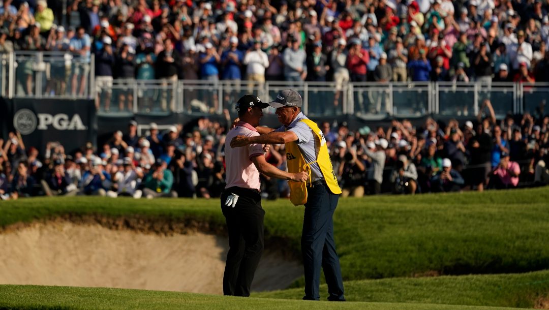 Justin Thomas celebrates with his caddie Jim "Bones" Mackay after winning the PGA Championship golf tournament in a playoff against Will Zalatoris at Southern Hills Country Club, Sunday, May 22, 2022, in Tulsa, Okla.