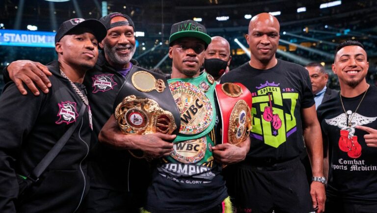 Errol Spence Jr. poses with his team after beating Yordenis Ugas, from Cuba, in a welterweight championship boxing match.