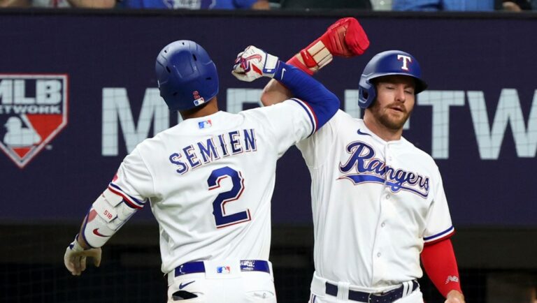 Texas Rangers Marcus Semien (2) celebrates with Robbie Grossman after a two-run home run against the Los Angeles Angels during the seventh inning of a baseball game Wednesday, June 14, 2023, in Arlington, Texas. (AP Photo/Richard W. Rodriguez)