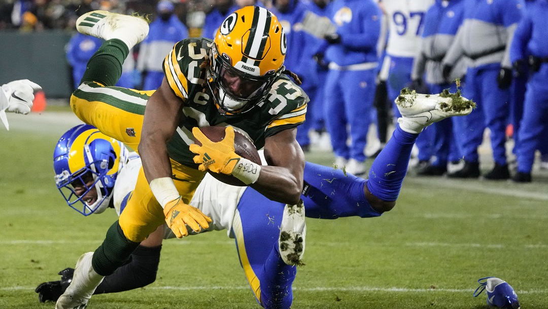 Green Bay Packers running back Aaron Jones (33) dives for a touchdown against the Los Angeles Rams in the second half of an NFL football game in Green Bay, Wis. Monday, Dec. 19, 2022. Running back Aaron Jones has agreed to remain with the Green Bay Packers on a restructured deal with a reduced salary for 2023.