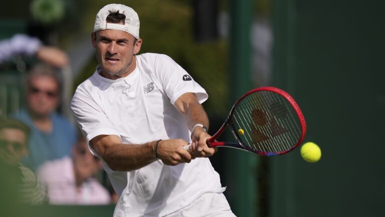 Tommy Paul of the US returns to Canada's Milos Raonic in a men's singles match on day four of the Wimbledon tennis championships in London, Thursday, July 6, 2023.