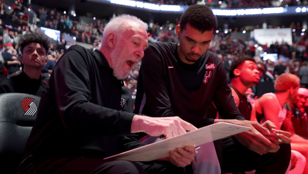 PORTLAND, OREGON - DECEMBER 28: Head coach Gregg Popovich talks with Victor Wembanyama #1 of the San Antonio Spurs before the game.