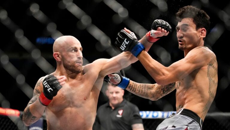 Alexander Volkanovski, left, hits Max Holloway in a featherweight title bout during the UFC 276 mixed martial arts event.