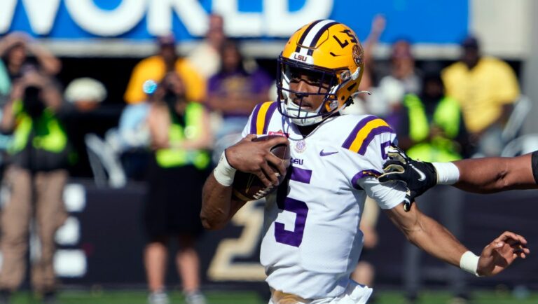 LSU quarterback Jayden Daniels (5) scrambles to get past Purdue defensive end Kydran Jenkins, right, during the first half of the Citrus Bowl NCAA football game Monday, Jan. 2, 2023, in Orlando, Fla. (AP Photo/John Raoux)