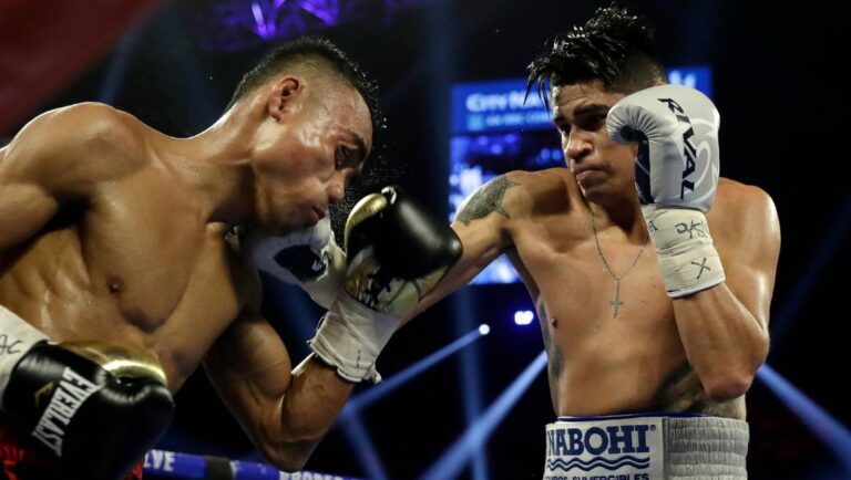 Emanuel Navarrete, of Mexico, right, punches Jeo Santisima, of the Philippines, during their super bantamweight boxing match.