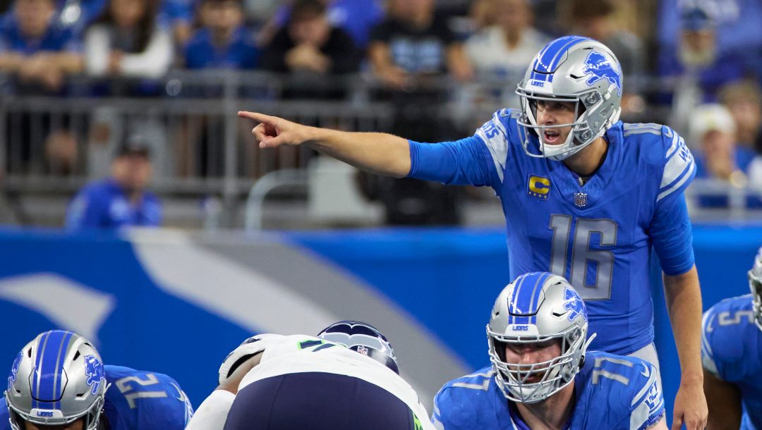 Lions player number 16 pointing down the field with other players crouching on the ground in front of him.