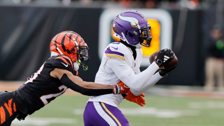 Minnesota Vikings wide receiver Jordan Addison (3) catches a pass then runs for a touchdown past Cincinnati Bengals cornerback DJ Turner II (20) during the second half of an NFL football game Saturday, Dec. 16, 2023, in Cincinnati. (AP Photo/Jay LaPrete)