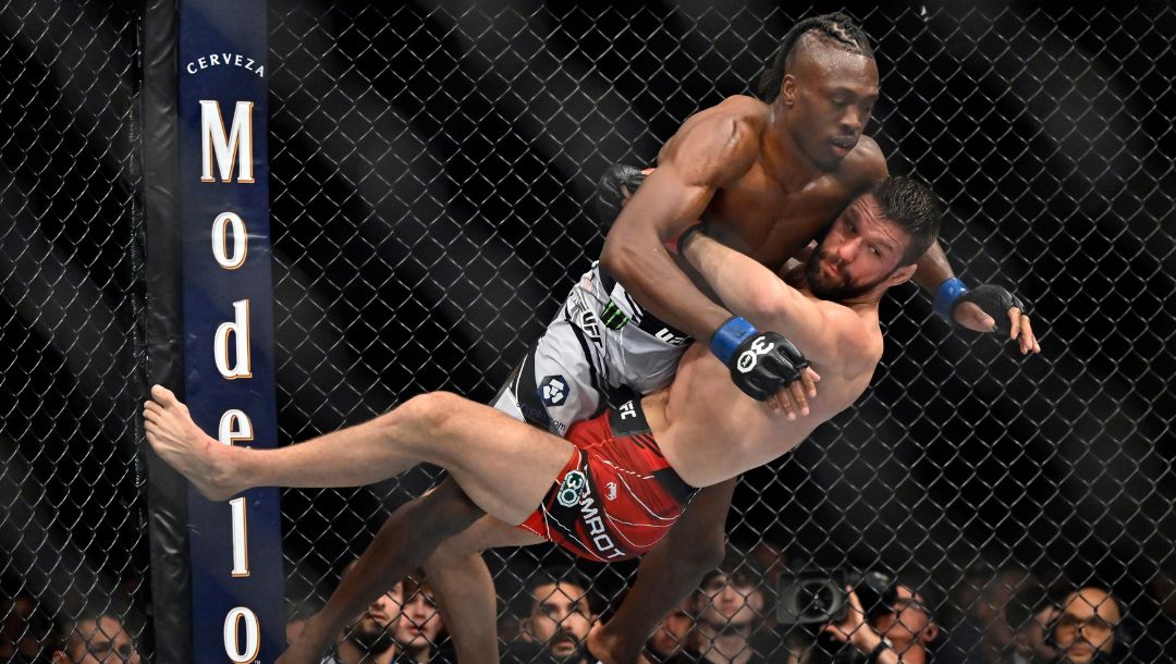 Mateusz Gamrot, bottom, pulls down Jalin Turner during a UFC 285 mixed martial arts lightweight bout Saturday, March 4, 2023.
