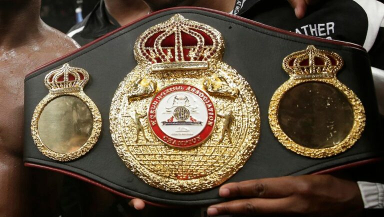 Floyd Mayweather Jr., center, poses with his corner and a champion's belt after his WBC-WBA welterweight title boxing fight.