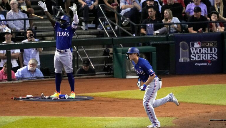 Texas Rangers' Corey Seager, right, watches his two-run home run as Adolis Garcia, left, reacts during the third inning in Game 3 of the baseball World Series against the Arizona Diamondbacks Monday, Oct. 30, 2023, in Phoenix.