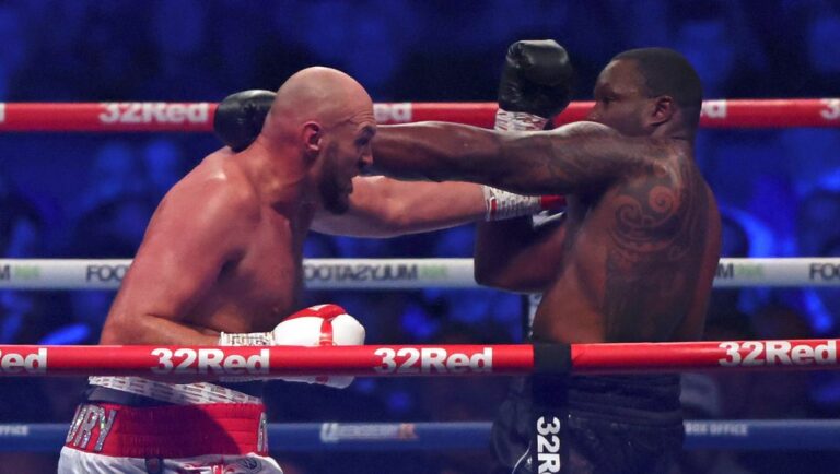 Britain's Tyson Fury, left, lands a blow on Britain's Dillian Whyte during their WBC heavyweight title boxing fight.