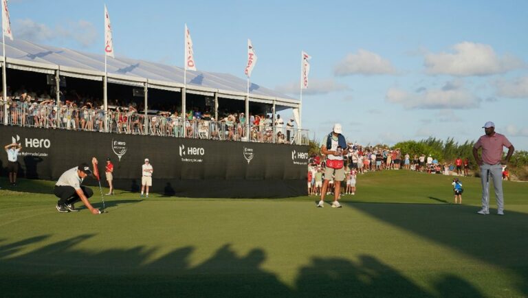 Viktor Hovland, of Norway, left, lines up a putt on the 18th green during the final round of the Hero World Challenge PGA Tour at the Albany Golf Club, in New Providence, Bahamas, Sunday, Dec. 4, 2022.