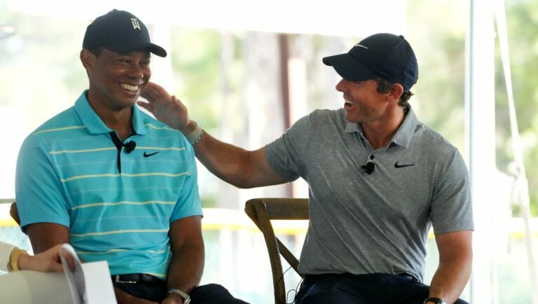 Golfers Tiger Woods, left, and Rory McIlroy share a laugh as they discuss the future home of their tech-infused golf league that will begin play next year, Tuesday, Feb. 21, 2023, on the campus of Palm Beach State College in Palm Beach Gardens, Fla.