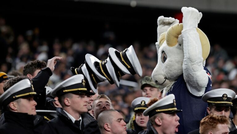 Navy midshipman and Bill the Goat during the second half of an NCAA college football game against Army on Saturday, Dec. 11, 2021, in East Rutherford, N.J. Navy won 17-13. (AP Photo/Adam Hunger)
