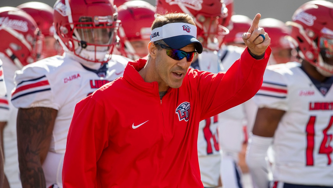 Liberty coach Jamey Chadwell leads his team onto the field to face UTEP in an NCAA college football game on Saturday, Nov. 25, 2023, in El Paso, Texas. Liberty became the first Division I team from Virginia to win 12 games in a season. (AP Photo/Andres Leighton)